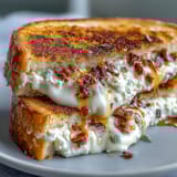 Oozing chèvre and cream cheese blend is drizzled with honey and sprinkled with red pepper flakes inside buttery bread. 