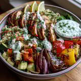 Freshly roasted paprika herb chicken sits atop fluffy quinoa with vibrant, tender vegetables and a swirl of rose harissa.