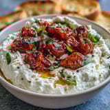 Velvety feta and cream cheese dip topped with sweet, caramelized roasted cherry tomatoes and fragrant basil leaves.  