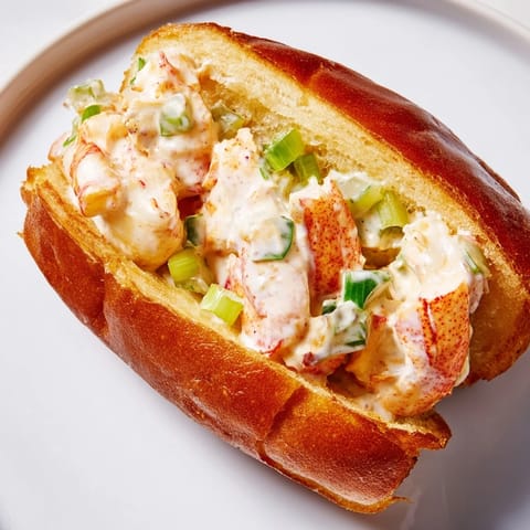 Gourmet New England Lobster Roll served with crisp potato chips and a lemon wedge.