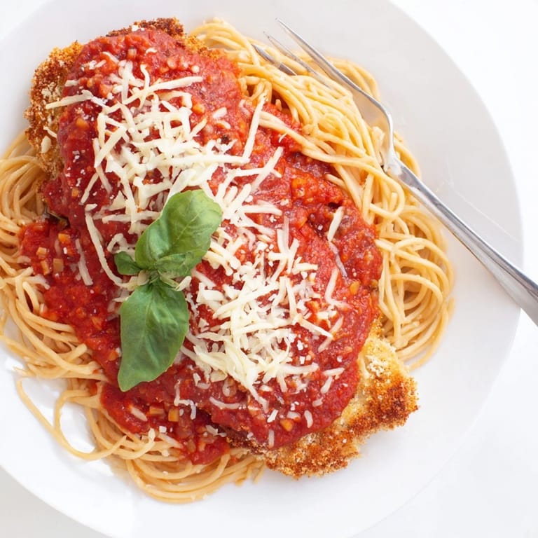 Savory Italian-American Chicken Parmesan ready to serve, garnished with fresh basil and a sprinkle of Parmesan.