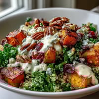 Roasted sweet potatoes and massaged kale in a Harvest Kale Quinoa Bowl, drizzled with creamy lemon tahini dressing.