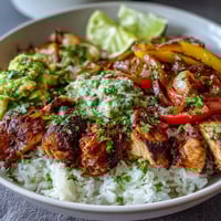 Golden-brown Sheet Pan Chicken Tinga Bowl components roasted with smoky chipotle and vibrant bell peppers on a baking sheet.