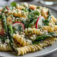 Bright spring pasta salad with lemon vinaigrette and crisp radishes, perfect for a light lunch or picnic side.